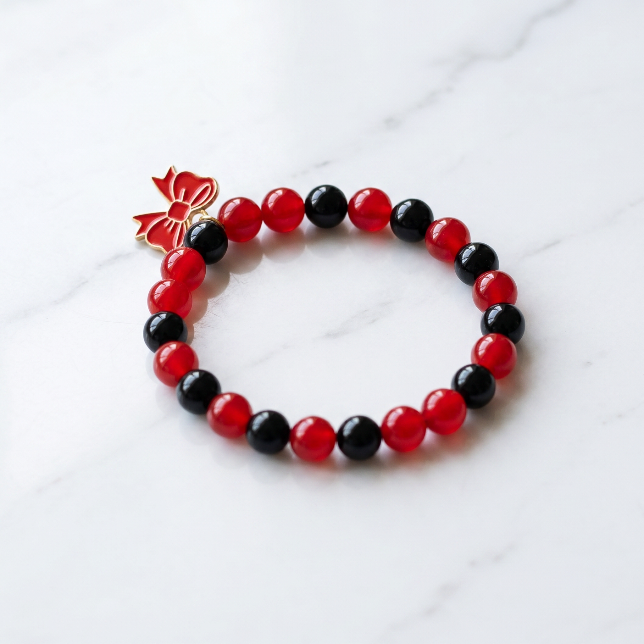 Handmade Red and Black Crystal Glass Bead Stretch Bracelet with Gold Enamel Bow Charm